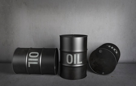 Three black oil drums stood in a concrete storage roomの写真素材