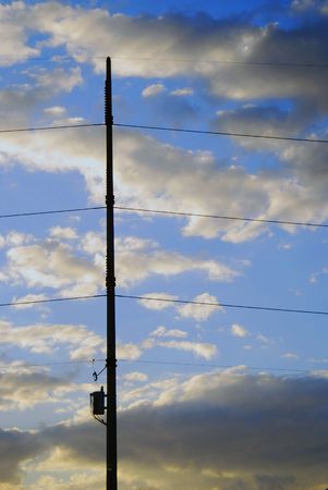Transformer and power lines are held in place by pole and magnificent cloudscape at sunset.の写真素材