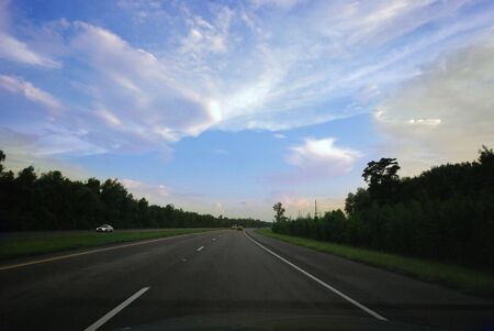Drive into the night as the sun sets on the highway.