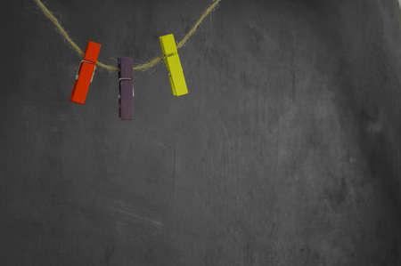 Clothespins in red, purple and yellow on ropeの写真素材