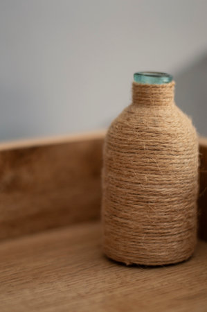 A decorative wrapped twine glass bottle on the bedside tableの写真素材