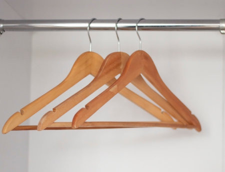 Three wooden hangers for clothes in the closetの写真素材