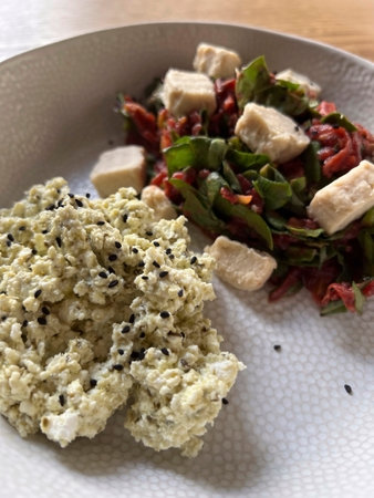 Tofu salad and quinoa with sesame seeds on a white plate.の写真素材
