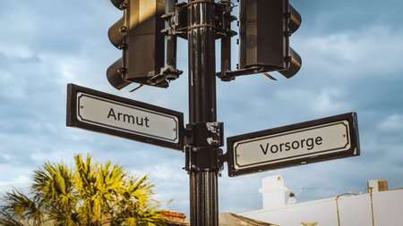 An image with a signpost pointing in two different directions in German. One direction points to precaution, the other points to povertyの写真素材