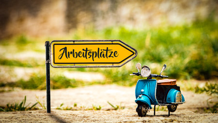 Image shows a signpost and a sign pointing towards jobs in German.