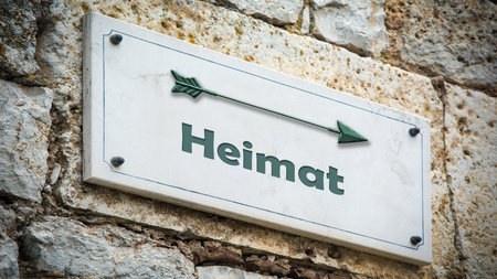 The picture shows a signpost and a sign that points in the direction of homeland in German.の写真素材