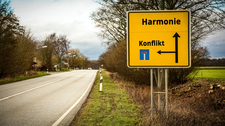 An image with a signpost pointing in two different directions in German. One direction points to harmony, the other points to conflict.の写真素材