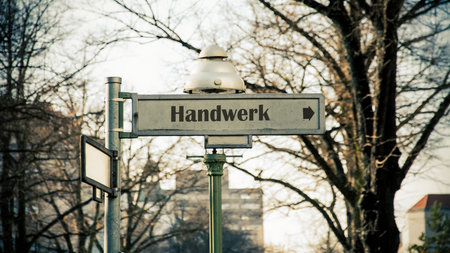 the picture shows a signpost and a sign that points in the direction of craftmanship in german.の写真素材