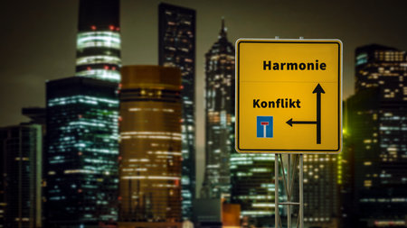 An image with a signpost pointing in two different directions in German. One direction points to harmony, the other points to conflict.の写真素材