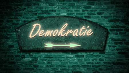 the picture shows a signpost and a sign that points in the direction of democracy in german.の写真素材