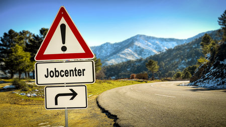 The picture shows a signpost and a sign that points in the direction of the job center in German.の写真素材