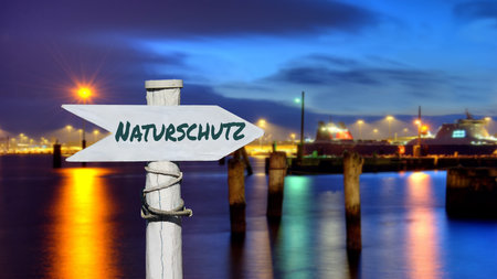 An image with a signpost in German pointing in the direction of nature conservation.の写真素材