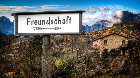 the picture shows a signpost and a sign that points in the direction of friendship in german.の写真素材
