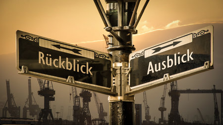 An image with a signpost pointing in two different directions in German. One direction points to outlook, the other points to backsightの写真素材