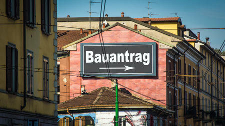 The picture shows a signpost and a sign that points in the direction of the building application in Germanの写真素材