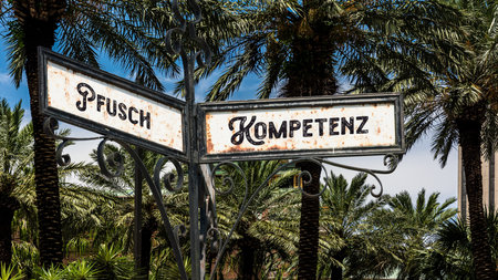 An image with a signpost pointing in two different directions in German. One direction points to competence, the other points to bungling.の写真素材