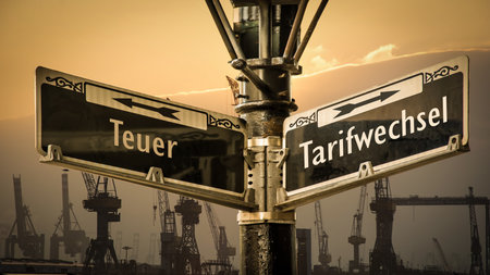 An image with a signpost pointing in two different directions in German. One direction points to Tariff Change, the other points to Expensive.の写真素材