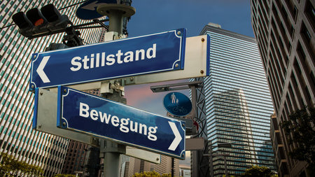 An image with a signpost pointing in two different directions in German. One direction points to move, the other points to standstill.の写真素材