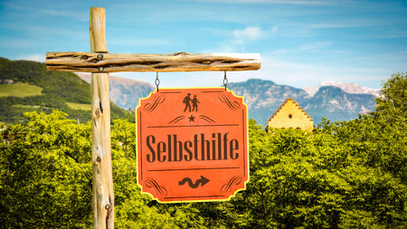 An image with a signpost in German pointing in the direction of self-help.の写真素材