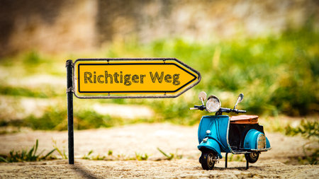 An image with a signpost in German pointing in the direction of the right way.の写真素材