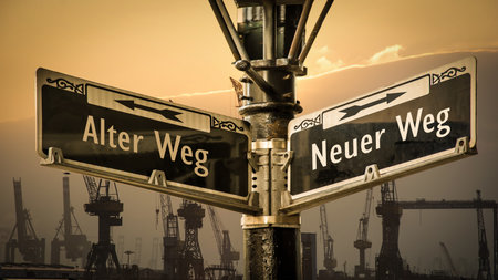 An image with a signpost pointing in two different directions in German. One direction points to New Path, the other points to Old Path.の写真素材