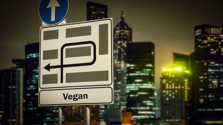 An image with a signpost in German pointing in the direction of Vegan.の写真素材