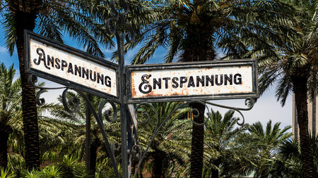 An image with a signpost pointing in two different directions in German. One direction points to relaxation, the other points to tension.の写真素材
