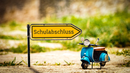 An image with a signpost in German pointing in the direction of graduation.の写真素材