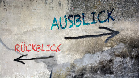 An image with a signpost pointing in two different directions in German. One direction points to outlook, the other points to backsightの写真素材