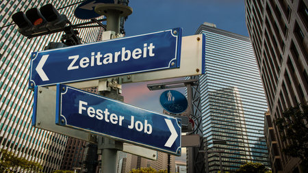 An image with a signpost pointing in two different directions in German. One direction points to permanent job, the other points to temporary work.の写真素材