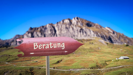 the picture shows a sign post and a sign pointing in the direction of advice in germanの写真素材