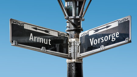 An image with a signpost pointing in two different directions in German. One direction points to precaution, the other points to povertyの写真素材