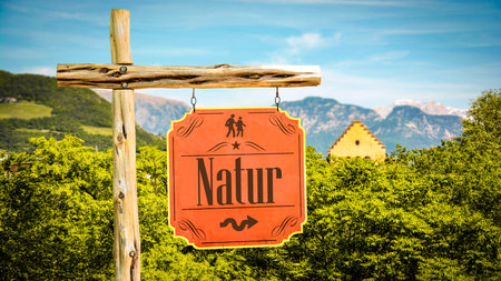An image with a signpost in German pointing in the direction of nature.の写真素材