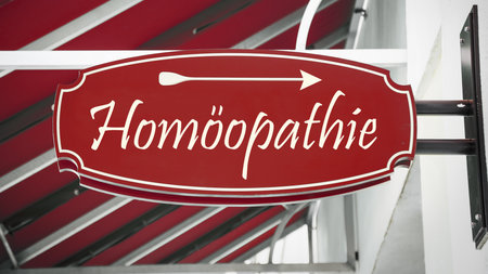 The picture shows a signpost and a sign that points in the direction of homeopathy in German.の写真素材
