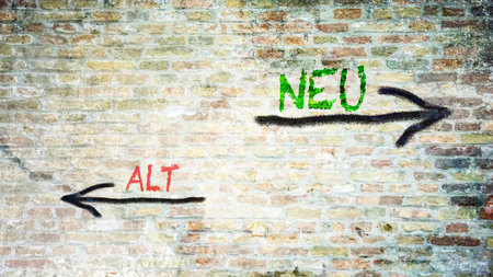 An image with a signpost pointing in two different directions in German. One direction points to 'neu' (new), the other points to 'alt' (old).の写真素材