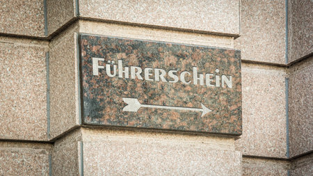 The picture shows a signpost and a sign that points in the direction of a driver's license in German.の写真素材