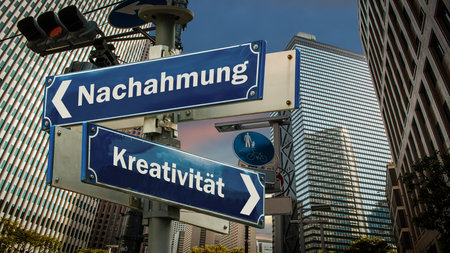 An image with a signpost pointing in two different directions in German. One direction points to creativity, the other points to imitation.の写真素材