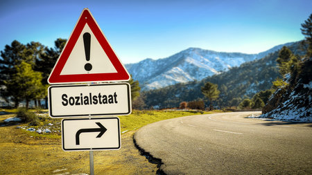 An image with a signpost in German pointing in the direction of the welfare state.の写真素材