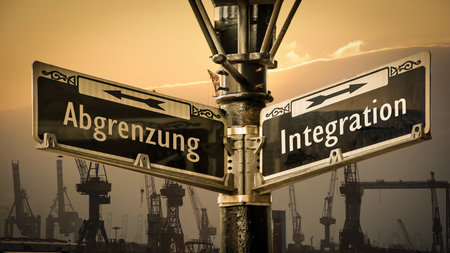 An image with a signpost pointing in two different directions in German. One direction points to integration, the other points to demarcation.の写真素材