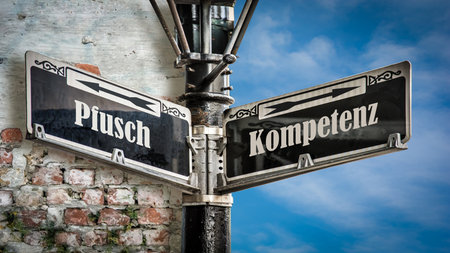 An image with a signpost pointing in two different directions in German. One direction points to...