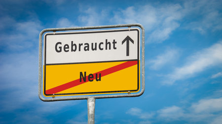 An image with a signpost pointing in two different directions in German. One direction is new, the other is used.の写真素材