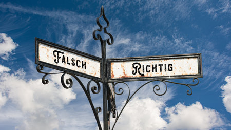 An image with a signpost pointing in two different directions in German. One direction points right,...