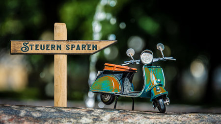 An image of a signpost in German pointing in the direction of save taxes.の写真素材