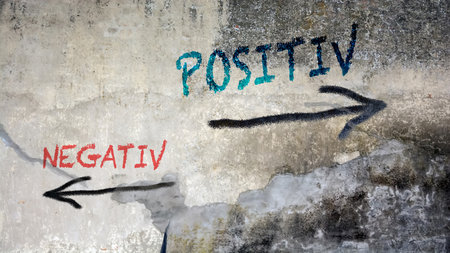 An image with a signpost pointing in two different directions. One direction points positive, the other points negative.の写真素材