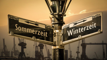 An image with a signpost in German pointing towards winter time.