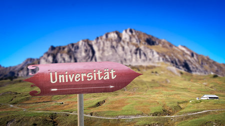 An image with a signpost in German pointing in the direction of the university.の写真素材