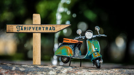 An image with a signpost in German pointing in the direction of the collective agreement.