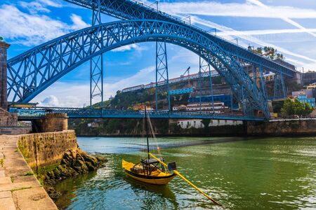 Boat in front of the Dom Luis I bridge on the Douro River in Porto, Portugalの写真素材