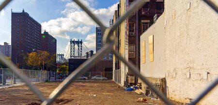 Vacant lot and Manhattan Bridge behind wire mesh in Manhattan in New York, USAの写真素材