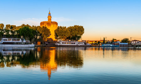 Tour Constance and tourist boats reflecting in the canal at Aigues-Mortes, Occitanie, Franceのeditorial素材